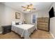 Cozy bedroom with a ceiling fan, mirror, wooden dresser, and nightstand with lamp at 151 Birkdale Dr, Salisbury, NC 28144