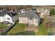 Backyard aerial view showcasing manicured lawn with a brick patio and well-maintained landscaping at 15138 Callow Forest Dr, Charlotte, NC 28273