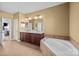 Spacious bathroom featuring a double vanity, soaking tub, and neutral tile flooring at 15138 Callow Forest Dr, Charlotte, NC 28273