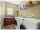 Laundry room includes washer, dryer, storage cabinets, and shelving for supplies at 15138 Callow Forest Dr, Charlotte, NC 28273