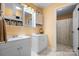 Bathroom featuring double vanities with white cabinets, stylish lighting, and a walk-in shower at 1514 Ring Tail Rd, Claremont, NC 28610