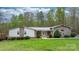 Charming ranch home featuring stone accents, a metal roof, and a well-manicured lawn and landscaping at 1514 Ring Tail Rd, Claremont, NC 28610