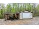 Storage shed features a large garage door, open carport, and gravel driveway at 1514 Ring Tail Rd, Claremont, NC 28610
