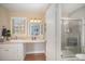 Bright bathroom with a vanity, mirror, drawers, and a shower with glass doors at 15920 Fieldstone Dr, Matthews, NC 28104