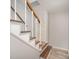 A staircase with wood and white risers and wood handrails at 15920 Fieldstone Dr, Matthews, NC 28104