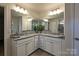 Bathroom with double sinks, granite countertops, gray cabinets, tiled floors, and a large mirror at 1766 Loggerhead Dr, Lancaster, SC 29720