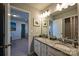 A bathroom features double sinks, granite countertops, and gray cabinets with an open doorway at 1766 Loggerhead Dr, Lancaster, SC 29720