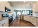 Bright kitchen features white cabinets, stainless steel appliances, granite countertops and hardwood flooring at 1766 Loggerhead Dr, Lancaster, SC 29720