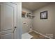 A compact laundry room features gray walls, tile flooring, shelf, and washer hookups at 1766 Loggerhead Dr, Lancaster, SC 29720