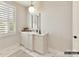 Bathroom showcasing white vanity with marble countertop, shuttered window, and stylish light fixture at 2013 Garden View Ln, Weddington, NC 28104