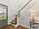 Home entryway featuring hardwood floors, staircase with wooden banister, light fixture, and front door view at 2013 Garden View Ln, Weddington, NC 28104
