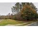 A glimpse of the charming house exterior through the autumn trees on a large lot at 2013 Garden View Ln, Weddington, NC 28104