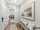 Hallway featuring a laundry room, artwork, a bench with pillows, and wood floors at 2013 Garden View Ln, Weddington, NC 28104