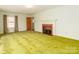 Spacious living room with fireplace, vintage green carpet, and generous natural light at 207 Oak Dr, Belmont, NC 28012