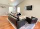 Cozy living room featuring hardwood floors, a black leather couch, and neutral color scheme at 218 Cottonwood Park Dr, Charlotte, NC 28214