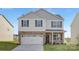 Charming two-story home with white siding, brick accents, black shutters, and a spacious two-car garage at 2319 Riggs Rd, Sherrills Ford, NC 28673