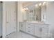 Elegant bathroom with a double vanity, marble floors, and modern lighting fixtures at 2622 Sheffield Crescent Ct, Charlotte, NC 28226
