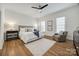Bright bedroom featuring hardwood floors, a ceiling fan, and a comfortable sitting area at 2622 Sheffield Crescent Ct, Charlotte, NC 28226