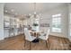 Dining area with hardwood flooring, modern chandelier, and large windows connected to the kitchen, perfect for Gathering meals at 2622 Sheffield Crescent Ct, Charlotte, NC 28226