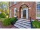 Elegant home entrance with arched brick, black door, decorative sidelights and stone steps at 2622 Sheffield Crescent Ct, Charlotte, NC 28226
