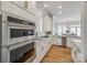 A modern kitchen featuring double ovens, white cabinets, stainless steel appliances, and an eat-in area at 2622 Sheffield Crescent Ct, Charlotte, NC 28226