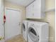 Functional laundry room with washer, dryer, and ample storage cabinets at 2905 Polo View Ln, Matthews, NC 28105