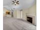 Spacious living area featuring a fireplace, ceiling fan, and an open concept design at 2905 Polo View Ln, Matthews, NC 28105