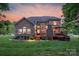 Spacious backyard with a deck, stone fireplace, and beautiful evening lighting at 3017 Chisholm Ct, Waxhaw, NC 28173