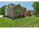 A home's brick exterior leads to a spacious wood deck featuring a stone fireplace at 3017 Chisholm Ct, Waxhaw, NC 28173