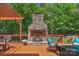 Deck with an outdoor fireplace and patio set with green trees in the background at 3017 Chisholm Ct, Waxhaw, NC 28173