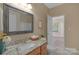 Bathroom featuring a granite countertop vanity, a large mirror, and an open doorway to another room at 3017 Chisholm Ct, Waxhaw, NC 28173