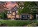 Elegant brick home with manicured lawn, lush landscaping and a picturesque sunset backdrop at 3017 Chisholm Ct, Waxhaw, NC 28173
