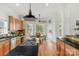 Gourmet kitchen with granite counters, wood cabinets, and gas cooktop island at 3017 Chisholm Ct, Waxhaw, NC 28173