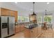 Open kitchen features stainless steel appliances and gas cooktop island at 3017 Chisholm Ct, Waxhaw, NC 28173