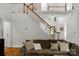 Inviting living room featuring hardwood floors, comfortable seating, and a staircase with wooden handrail at 3017 Chisholm Ct, Waxhaw, NC 28173