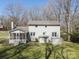 View of the back exterior with a screened-in porch, an additional utility shed and a nice, green lawn at 306 7Th Street Ne Pl, Conover, NC 28613