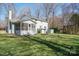 Spacious backyard view of home with a screened porch and mature trees at 306 7Th Street Ne Pl, Conover, NC 28613