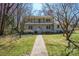 Two-story home boasting a walkway through the grass to a gray painted brick and a second story balcony at 306 7Th Street Ne Pl, Conover, NC 28613