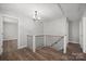 Hallway features wood flooring, metal stair railing, and contemporary chandelier at 306 7Th Street Ne Pl, Conover, NC 28613