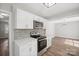 Updated kitchen with a view into the dining room, showcasing stainless steel appliances at 306 7Th Street Ne Pl, Conover, NC 28613