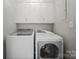 Modern laundry room features white washer and dryer, upper cabinets, and neutral paint at 306 7Th Street Ne Pl, Conover, NC 28613