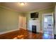 Cozy bedroom featuring hardwood floors, a fireplace, and an open doorway to the kitchen at 312 Gold Hill Ave, Rockwell, NC 28138