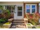 Charming brick home featuring a welcoming front entrance with beautiful plantings and a 'Welcome' mat at 312 Gold Hill Ave, Rockwell, NC 28138