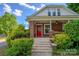 Inviting covered porch and front entry with a vibrant red door and stone steps at 312 Gold Hill Ave, Rockwell, NC 28138