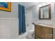 Bright bathroom features a tub with stylish blue shower curtain, and classic vanity at 3808 Severn Ave, Charlotte, NC 28210