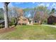 Charming brick home featuring a lush green lawn, mature trees, and classic black shutters at 3808 Severn Ave, Charlotte, NC 28210