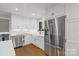 Bright kitchen featuring white cabinets, stainless steel refrigerator, and modern fixtures at 3808 Severn Ave, Charlotte, NC 28210