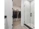 Bathroom featuring a glass shower, view into walk-in closet, white cabinets and grey tile floors at 403 Old Town Village Rd, Waxhaw, NC 28173
