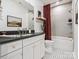 Well-lit bathroom featuring a white vanity, patterned tile floor, and a shower-tub combo at 403 Old Town Village Rd, Waxhaw, NC 28173