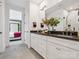 Bathroom featuring double sinks, black countertops, white cabinets, and a view into the bedroom at 403 Old Town Village Rd, Waxhaw, NC 28173